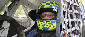 Derek Tohill in his racing car with branded helmet